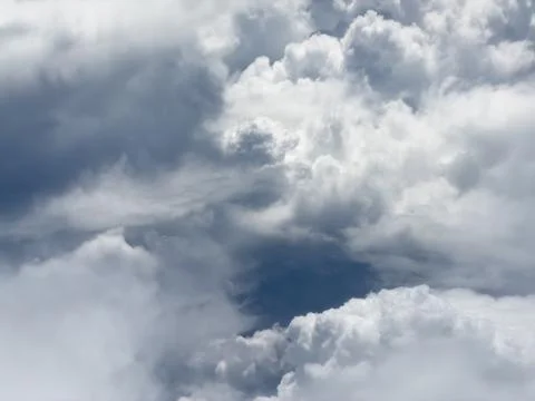 Voluminous clouds drift across a deep blue sky Фото