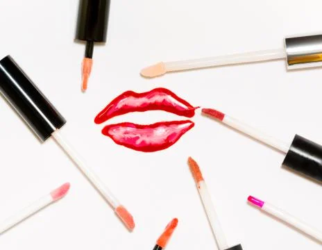 Voluminous sparkling painted lips and a lot of lip gloss brushes. Stock Photos