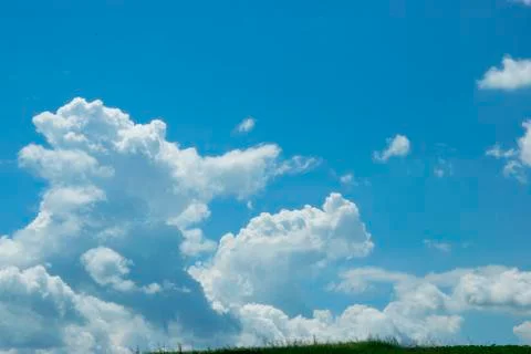 Voluminous white clouds in the blue sky, beautiful summer landscape. Stock Photos
