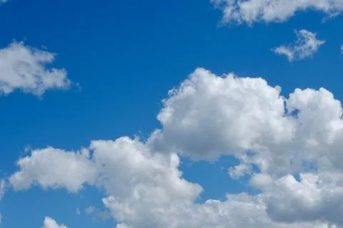 Voluminous white cloudscape on vivid blue sky Stock Photos