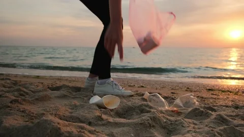 Volunteer cleaning the beach of plastic garbage. Woman picking up trash Stock Footage 197540801