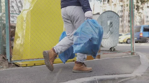 A volunteer collected garbage in a forest zone and takes it to garbage container Video stock 127100946
