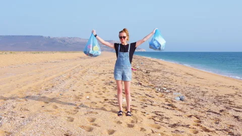 A volunteer collecting garbage on the beach Video stock 145646432