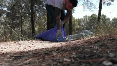 Volunteer man picking up plastic bottles in trash bag ecology nature pollutio Stock Footage 132255174