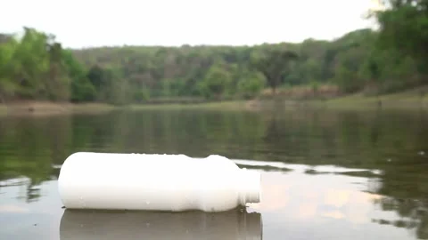 The volunteer picking up a bottle plastic in the river , protect environment Видео 158532416