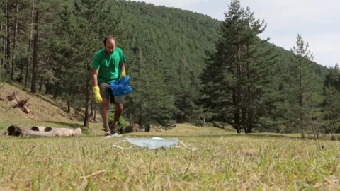 Volunteer picking up garbage in the forest Stock Footage 137162144