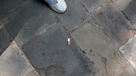 Volunteer picks up a cigarette butt from the ground, highlighting the human Stock Footage 243760428