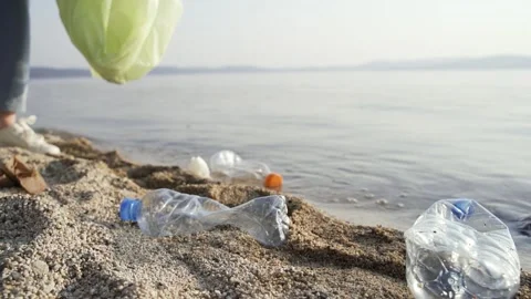 A volunteer puts empty plastic bottles, dirty napkins and used papers in a Video stock 157006626