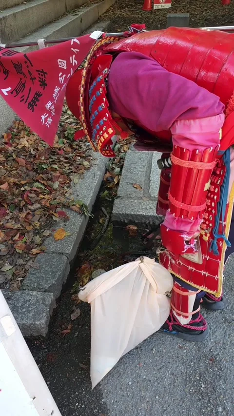 Volunteer in Samurai Armor Cleaning Drainage Grate at Osaka Castle Park. Stock Footage 340594297