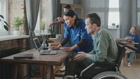 Volunteer Setting Up Wi-Fi Router for Handicapped Man Stock Footage 160431008