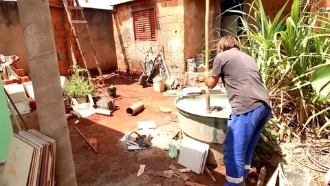 A Volunteer Worker Cleaning up after Working on a Neighbor’s House. Stock Footage 118933678
