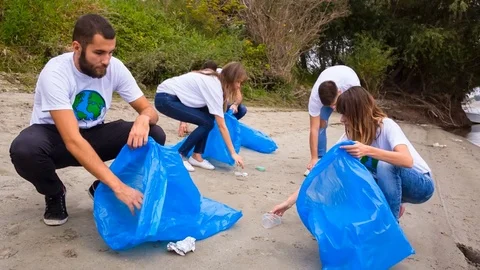 Volunteers cleaning up river beach Stock Footage 76671305