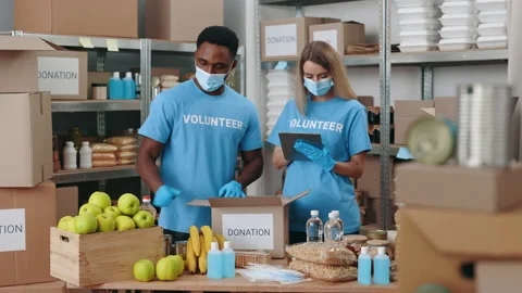 Volunteers in masks using tablet for work at food bank Stock Footage 201392489