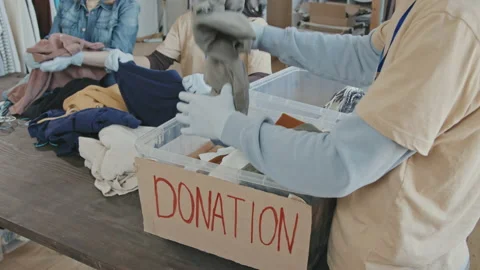 Volunteers Sorting out Donation Containers with Clothes Stock Footage 160430565