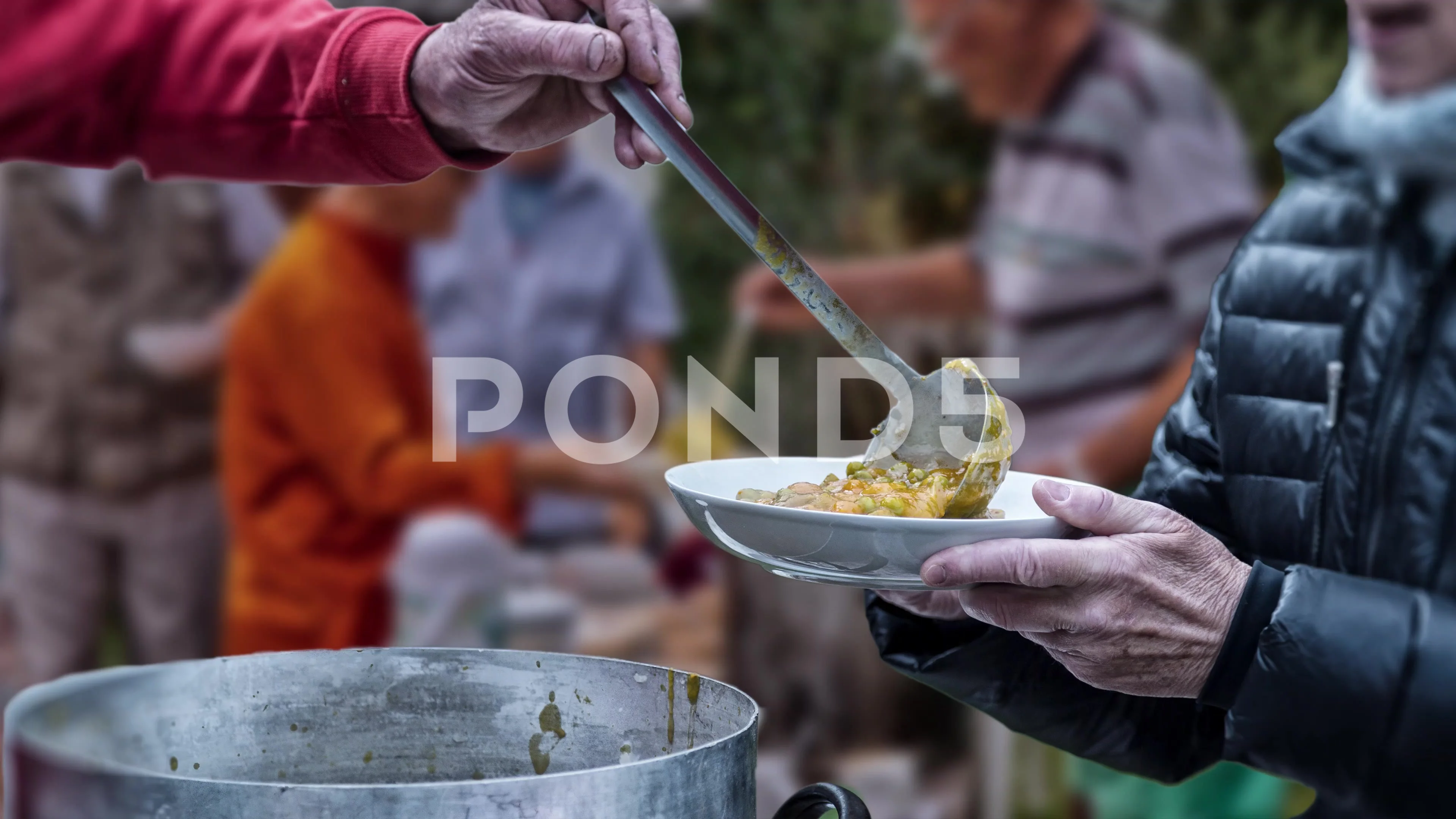 Volunteers In Soup Kitchen Serving Food