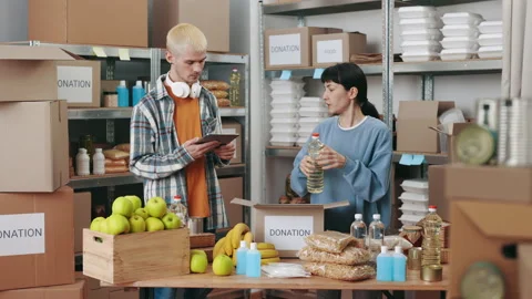 Volunteers using tablet and packing donation box Stock Footage 186607119