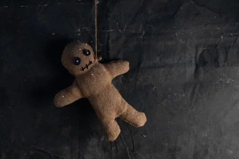 Voodoo doll on a black background with dramatic lighting. The concept of witc Stock Photos