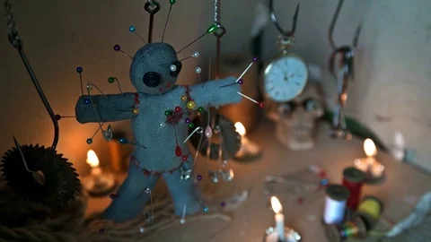 The voodoo doll swinging on the hook over the ritual table Stock Footage 78347919