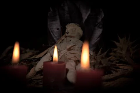 Voodoo Doll on a wooden background with dramatic lighting. Stock Photos