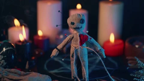 Voodoo Magic concept. Voodoo doll studded with needles with pierced rag heart Stock Footage 159854324