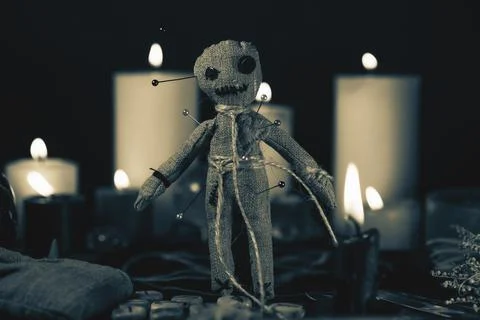 Voodoo Magic concept. Voodoo doll studded with needles with pierced rag heart on Stock Photos