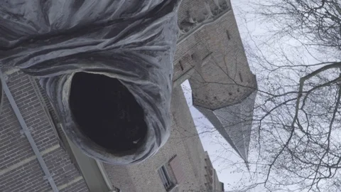 Vortex of a faceless statue with and old medieval tower background Stock Footage 126113943