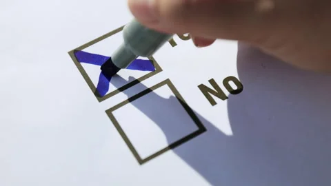 Vote, hand marking a blue cross in the Yes box on a questionnaire Stock Footage 328233409