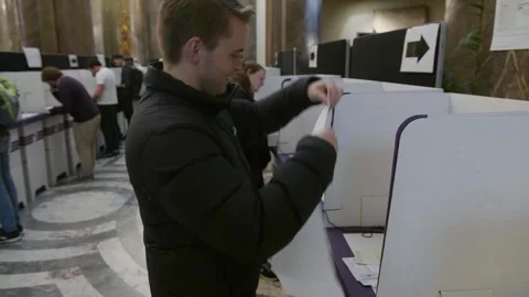 A voter posts a ballot paper into the ballot box Stock-Footage 345299092