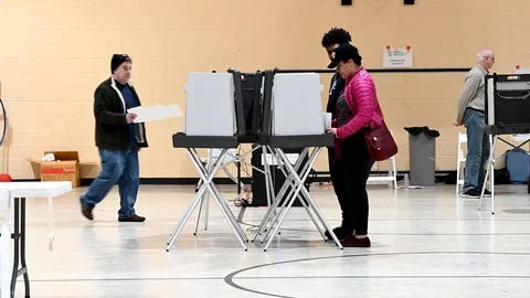 Voters exit voting area after casting their primary ballots. Stock-Footage 126129350