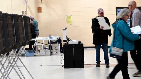 Voters insert their marked ballots in optical scanner. Stock Footage 126129006