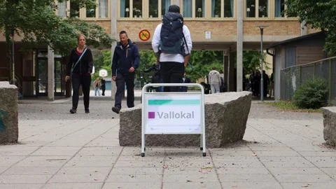 Voters walk by polling station on election day in Stockholm, Sweden Stock Footage 254998317