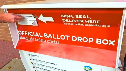 Voting Closeup – Hand Submits Mail-In Ballot Envelope Into Official Ballot Box Stock Footage 316707938