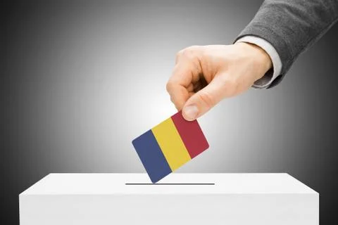 Voting concept - male inserting flag into ballot box - chad Foto stock