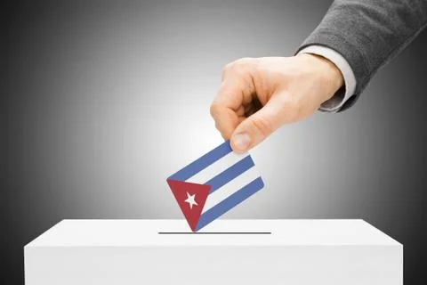 Voting concept - male inserting flag into ballot box - cuba Фото