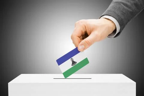 Voting concept - male inserting flag into ballot box - lesotho Stockfoto's