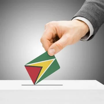 Voting concept - Male inserting flag into ballot box - Guyana 写真素材