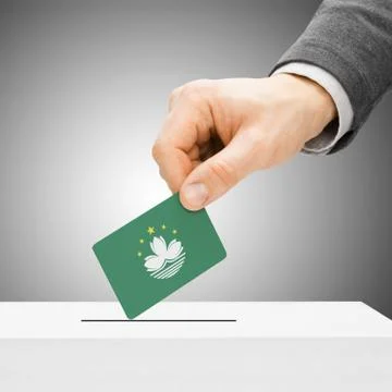 Voting concept - Male inserting flag into ballot box - Macau Stock Photos