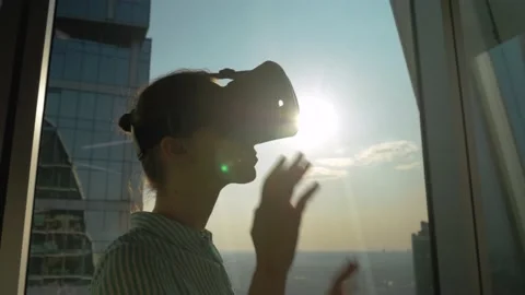 VR concept - young woman using virtual reality headset against skyscraper window Vidéo 145155418