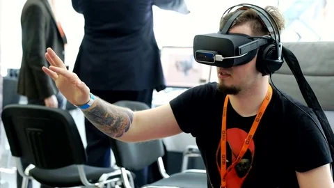 VR conference visitor tests virtual reality helmet Stock Footage 76938822