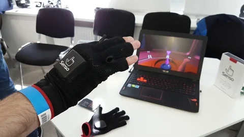 VR conference visitor tests virtual reality gloves Stock Footage 77002740