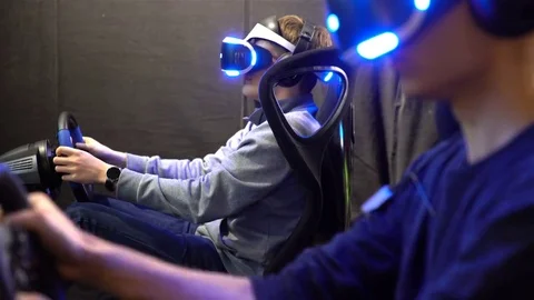 VR games. Teens use virtual reality helmets, racing simulator. Stock Footage 69233054