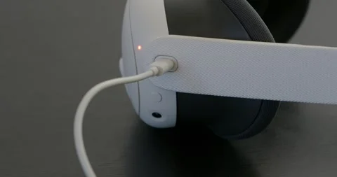 VR Headset charging from usb cable, changes light from orange to green. Stock Footage 256184988