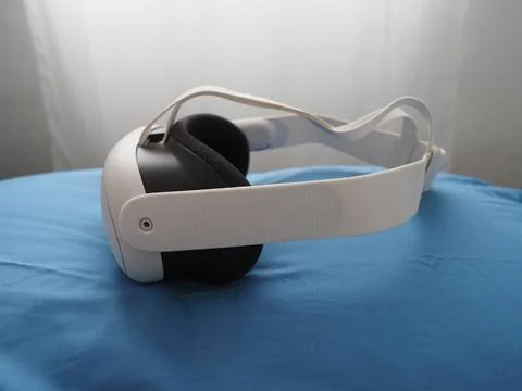 VR headset on pillow. Interacting with Augmented Reality lying on bed. Stock Photos