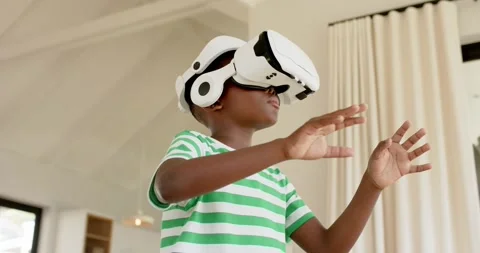 As VR headset is starting, child is sweeping arms and manipulating virtual Stock Footage 345063184