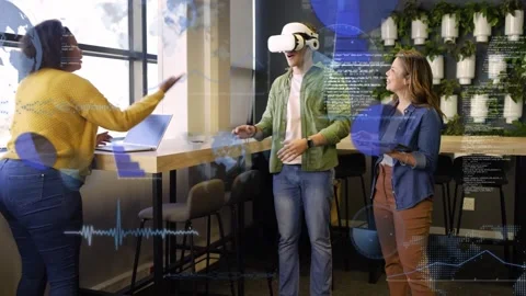 VR user wearing headset and raising hand, colleagues using laptop and tablet 库存影片 334373310
