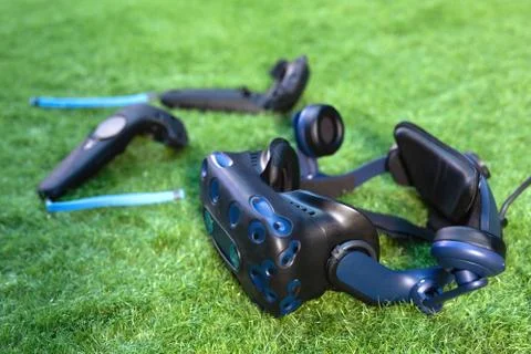 VR virtual reality headset and controllers over green background. Stock Photos