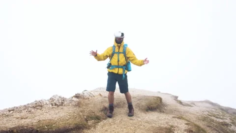 VR virtual reality headset. Young man hiker moving hands on cloudy sky and fog Stock Footage 239024331