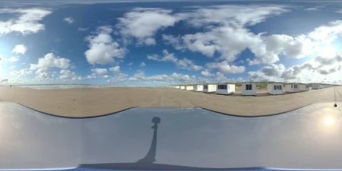VR360, Car drives over sandy beach with bath houses, North Sea, VR Stock Footage 117539469