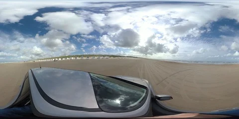 VR360, Car drives over sandy beach with bath houses, North Sea, VR Stock Footage 117709062