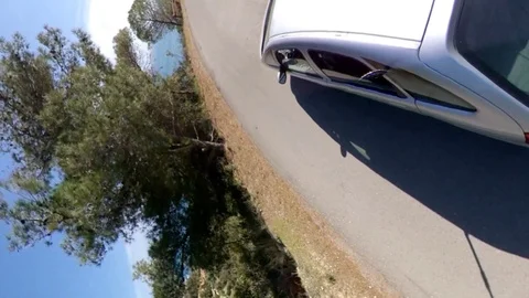 VR360 effect a car runs along a panoramic road on the sea in a sunny evening Stock Footage 107192310